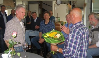 Henk Visscher ontvangt de bloemen